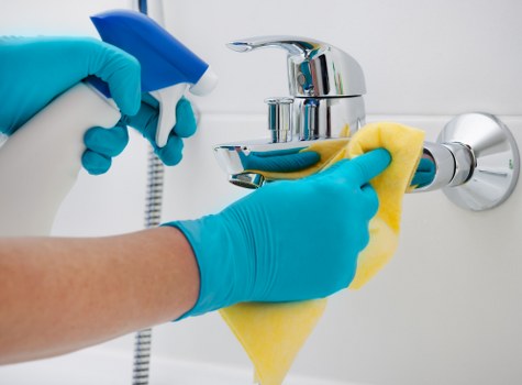 Cleaner sanitising a commercial kitchen or staff break area